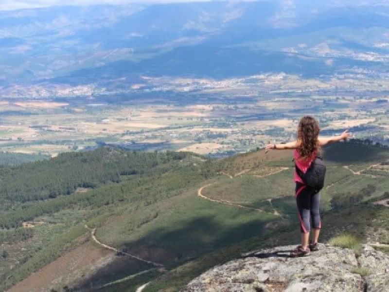 mulher de braços abertos a observar a paisagem