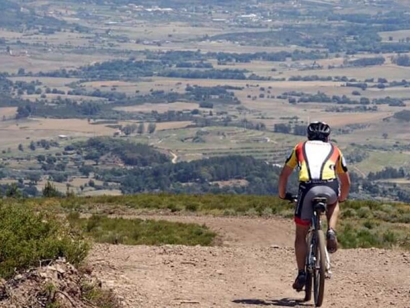 homem de bicielata descer uma estrada de terra