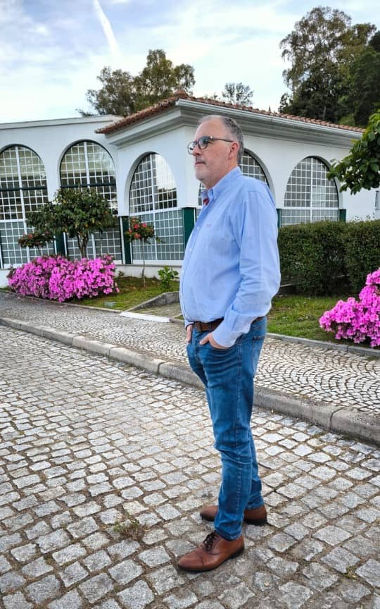 homem de pé com casa por trás